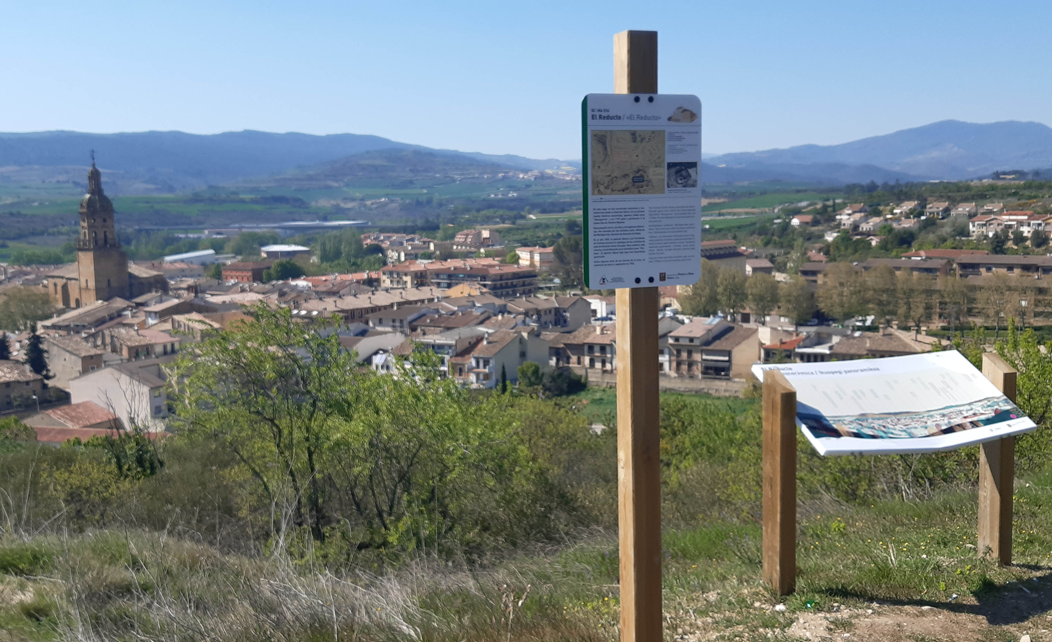 paneles del sendero y detrás el pueblo de Puente la Reina